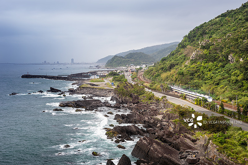 阴天，倾斜的列车行驶在悬崖海岸线上，风景如画图片素材