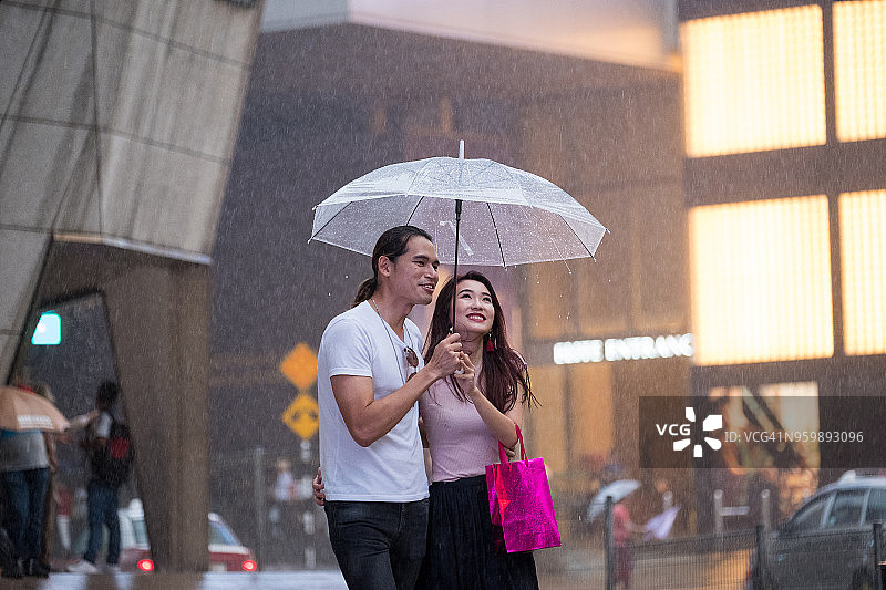 年轻情侣在雨中购物图片素材