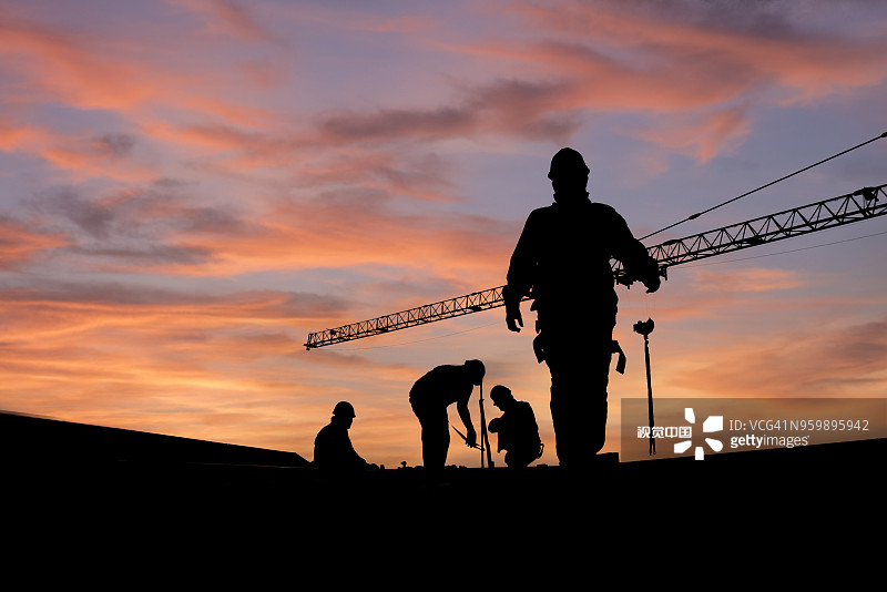 建筑工程师身穿安全服检查金属屋顶施工，屋顶工业概念图片素材