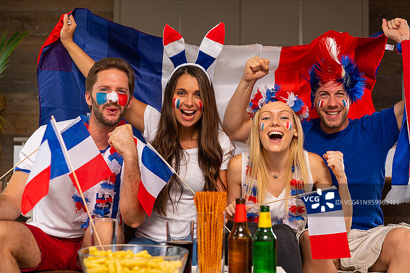 在家中观看足球比赛的有趣的法国球迷图片素材