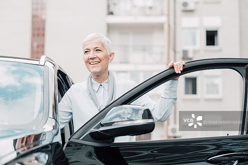 年长的女商人进入商务轿车图片素材