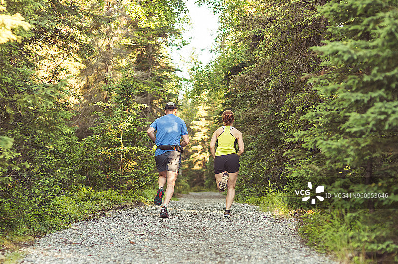 在森林中越野跑的一对年长的夫妇图片素材