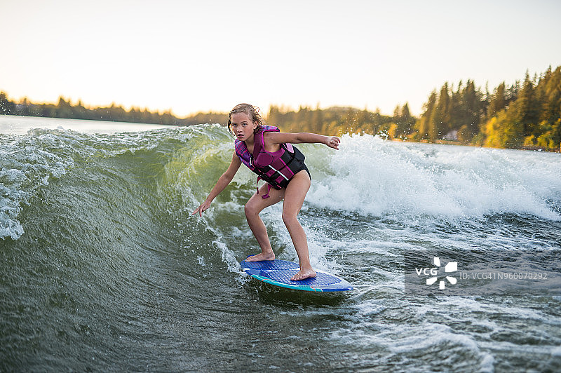 少女在湖上玩尾波冲浪图片素材