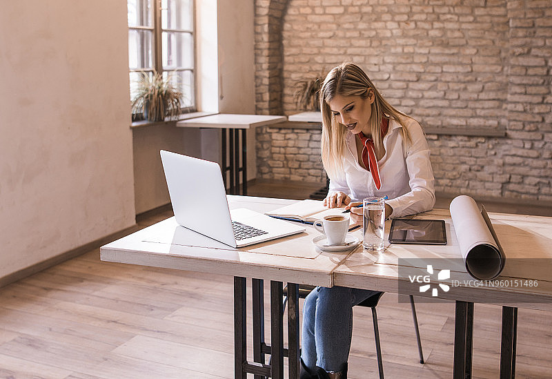 办公室里微笑的女性商人在桌前工作图片素材