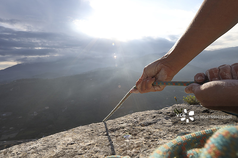 攀岩者的手与绳索，远山之上图片素材