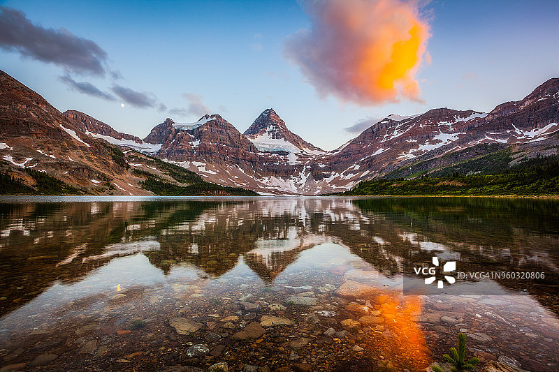 日落时分阿西尼博因山在马戈格湖的倒影图片素材