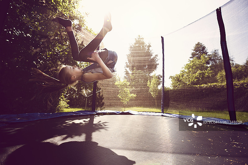 在蹦床上做翻筋斗的女孩（10-11岁）图片素材
