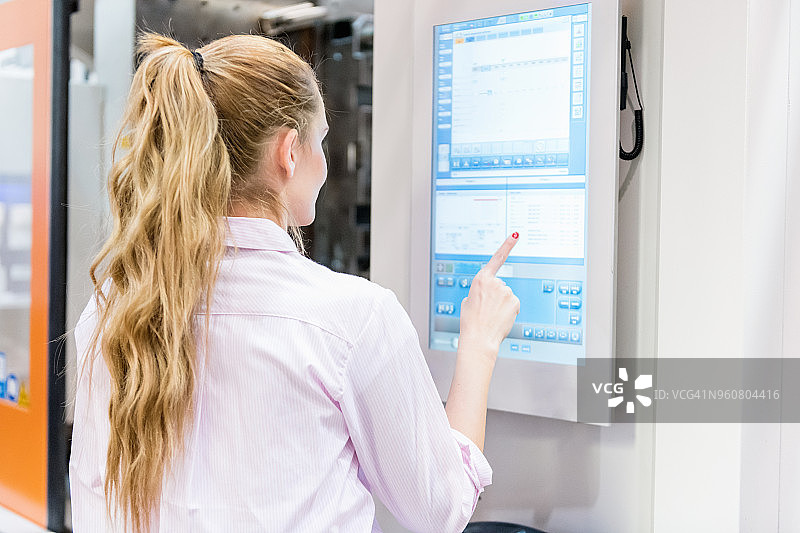 女工程师操作触摸屏和工业设备图片素材