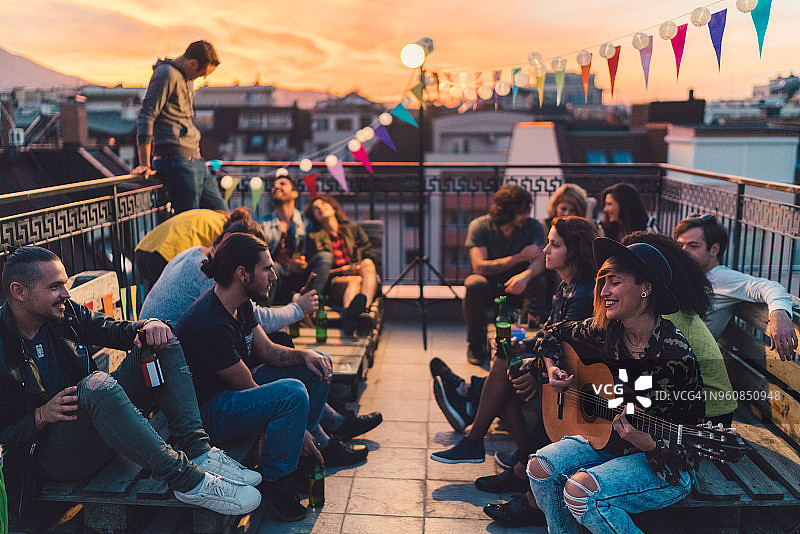 朋友们在屋顶派对上喝啤酒弹吉他图片素材