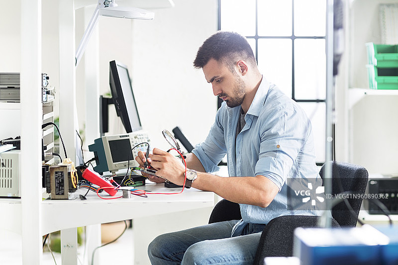在电子实验室工作台工作的工程师图片素材