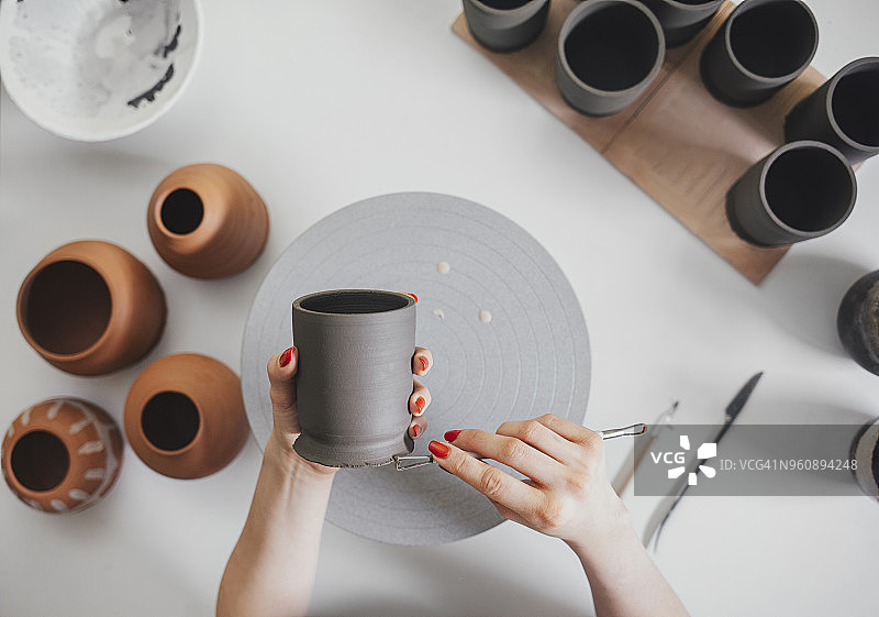 女陶艺师在工作室的桌子上制作陶瓷的特写镜头图片素材