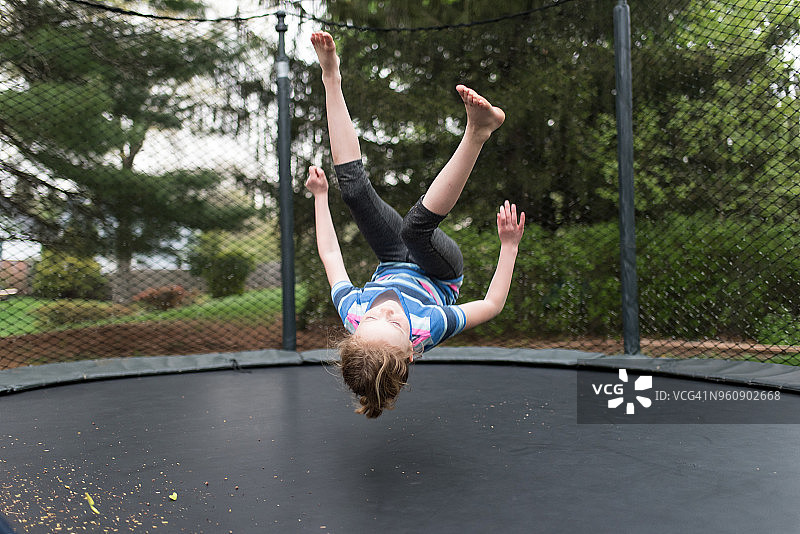 在公园蹦床上跳跃的快乐女孩图片素材