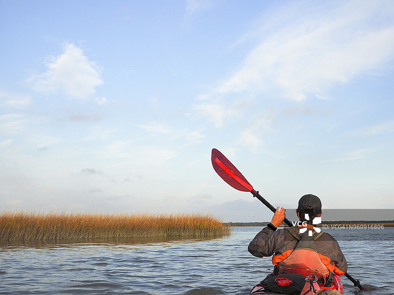 男子在哈特拉斯角国家海岸湖上划皮划艇的背影图片素材