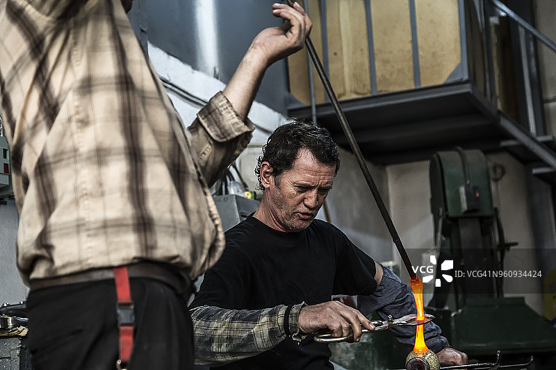 玻璃吹制工人在车间切割玻璃图片素材