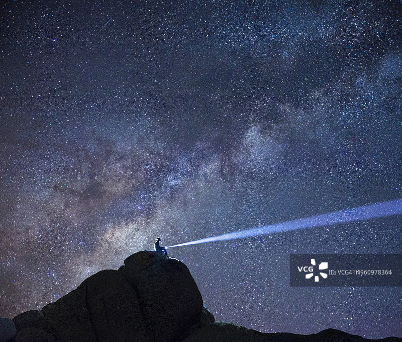 徒步旅行者在约书亚树国家公园星空下的山顶剪影图片素材