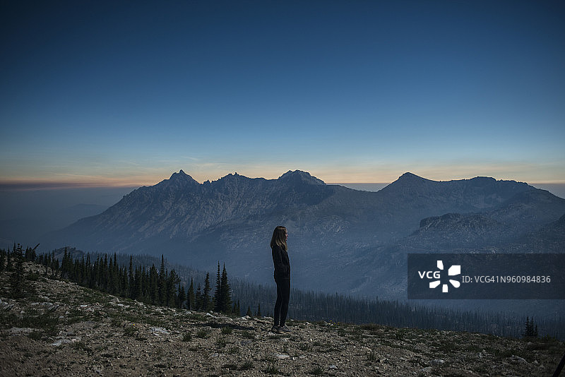 锯齿山脉，女子站在悬崖边的侧面视角图片素材