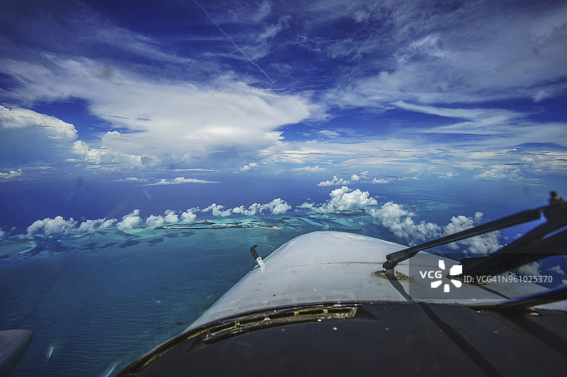 飞机飞过蓝色天空的海景图片素材