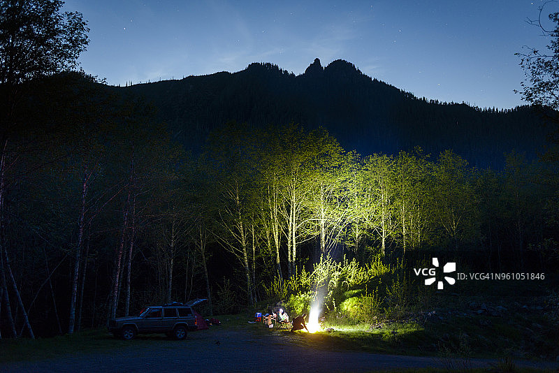 徒步者在黄昏时分在山边露营图片素材