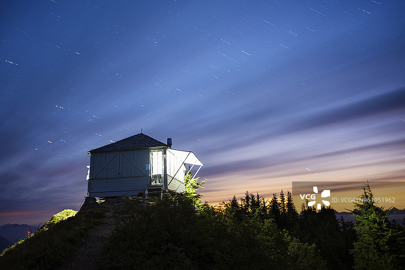 夜晚山间云雾缭绕的灯光小屋图片素材