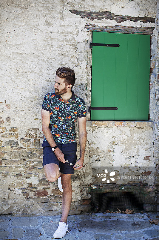 靠在老房子墙上的男人图片素材