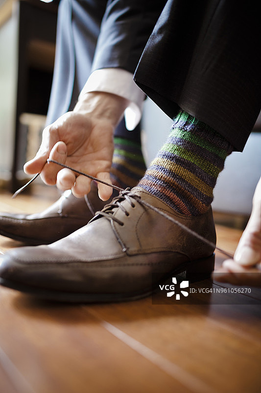 新郎在家系鞋带的下半身视角图片素材