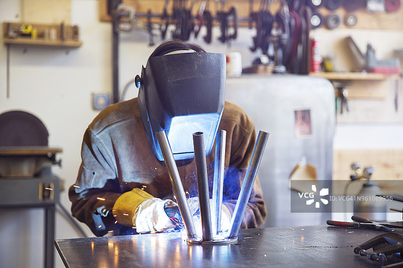 工人在木材店焊接金属凳子图片素材