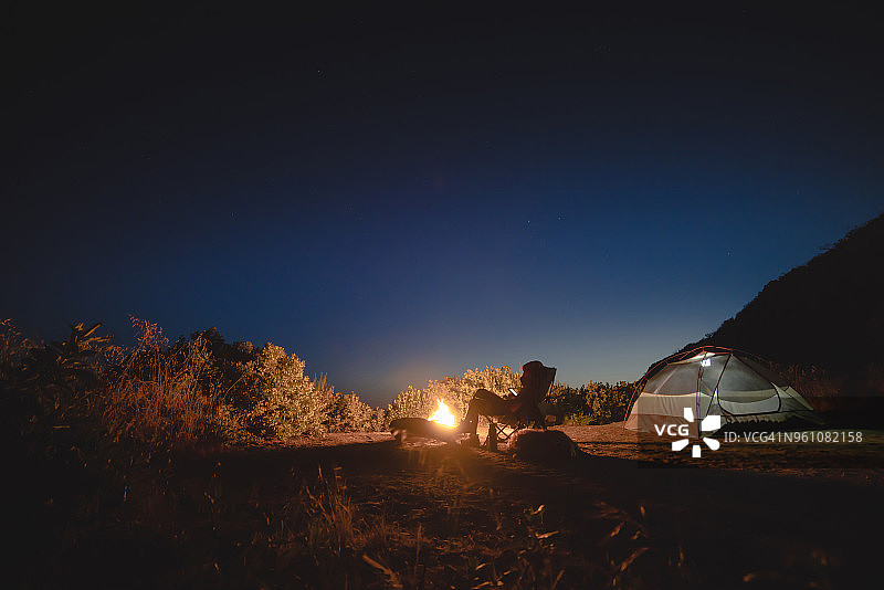 女人在露营地坐在天空下使用平板电脑图片素材