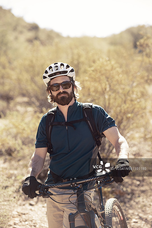 站在山地自行车旁的自信骑行者图片素材