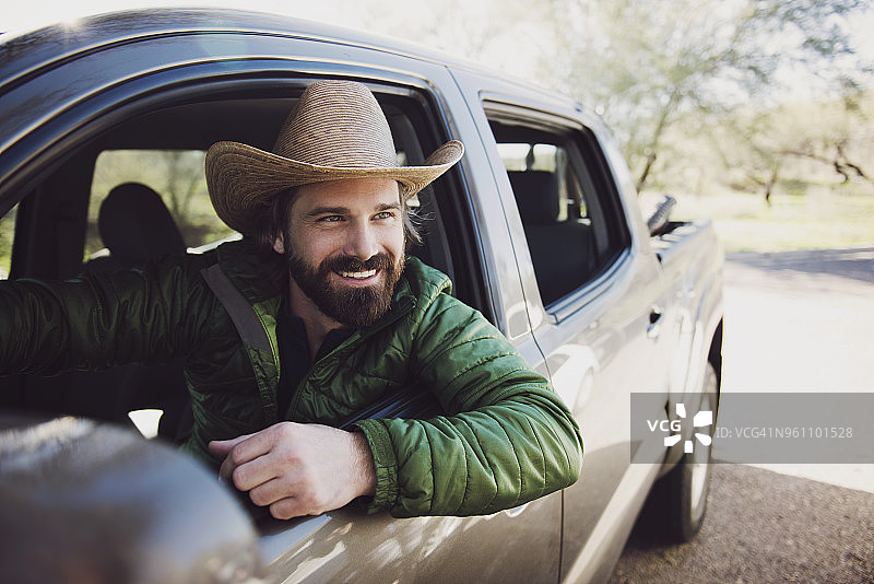 快乐的男人坐在皮卡车里图片素材