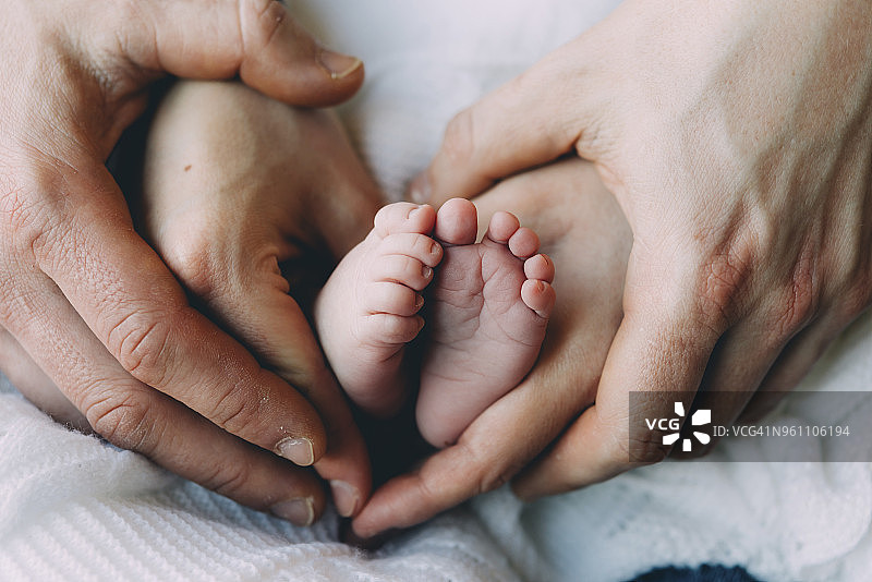 父母的手握着婴儿的脚图片素材