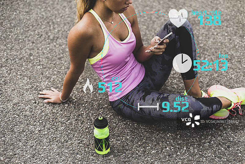运动型年轻女子在使用智能手机图片素材