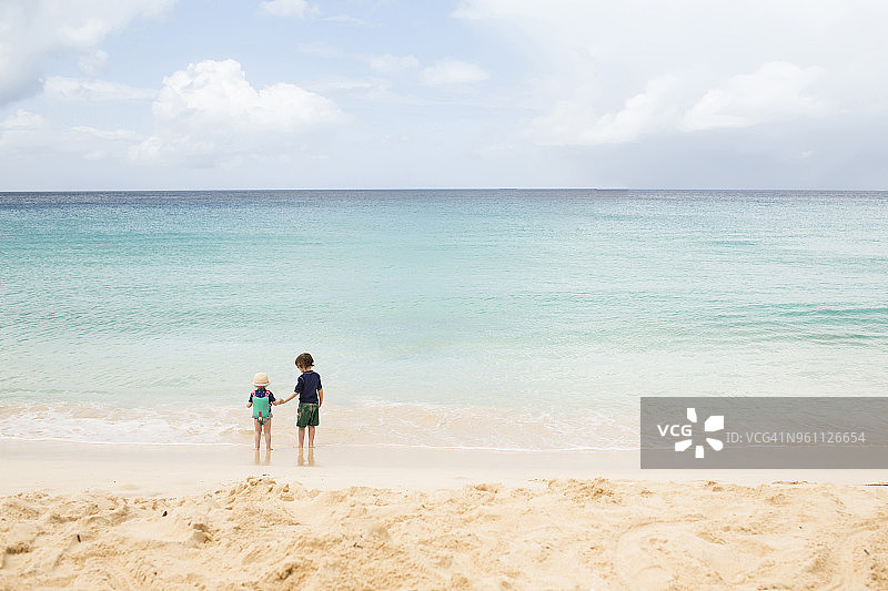 在海滩上玩耍的兄弟姐妹背影图片素材