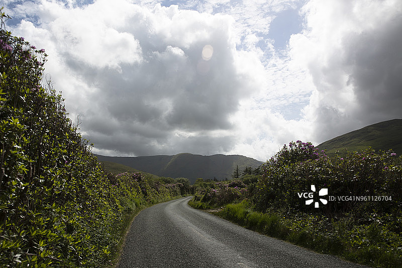 多云天空下的空旷山路图片素材