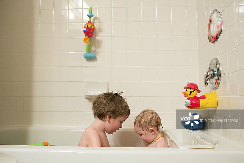 兄弟姐妹坐在家里的浴缸里图片素材