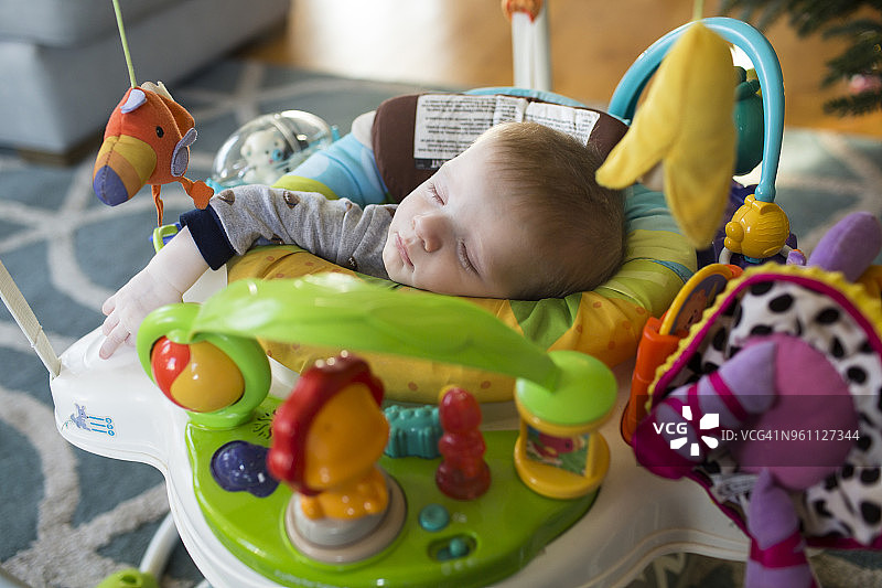 俯视：在学步车里睡觉的男婴图片素材