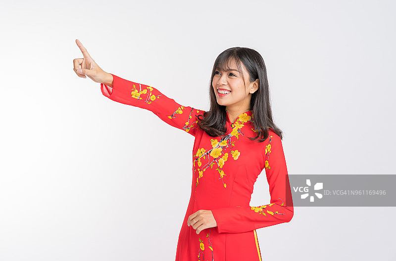 年轻女人身穿越南红色奥黛，挥手致意图片素材