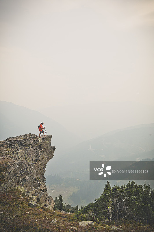 雾天，徒步者站在悬崖边远眺群山图片素材
