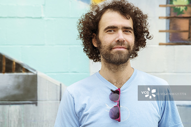 靠墙站立的微笑男人肖像图片素材