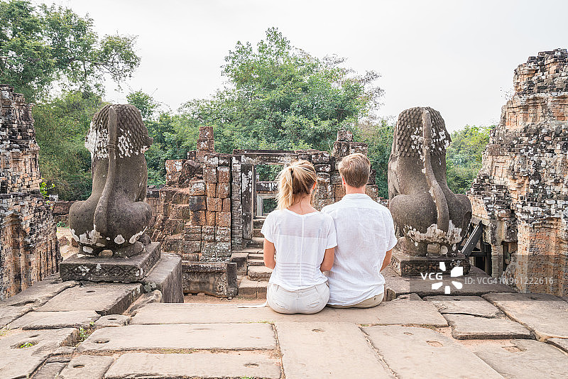 年轻情侣欣赏柬埔寨吴哥窟古老寺庙图片素材
