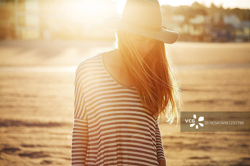 日落时分站在海滩上的女人图片素材