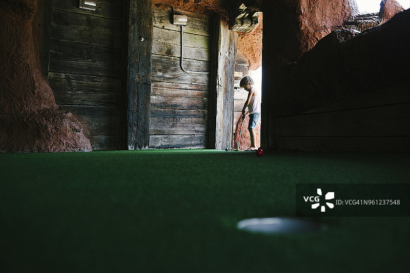 女孩在门口玩迷你高尔夫图片素材