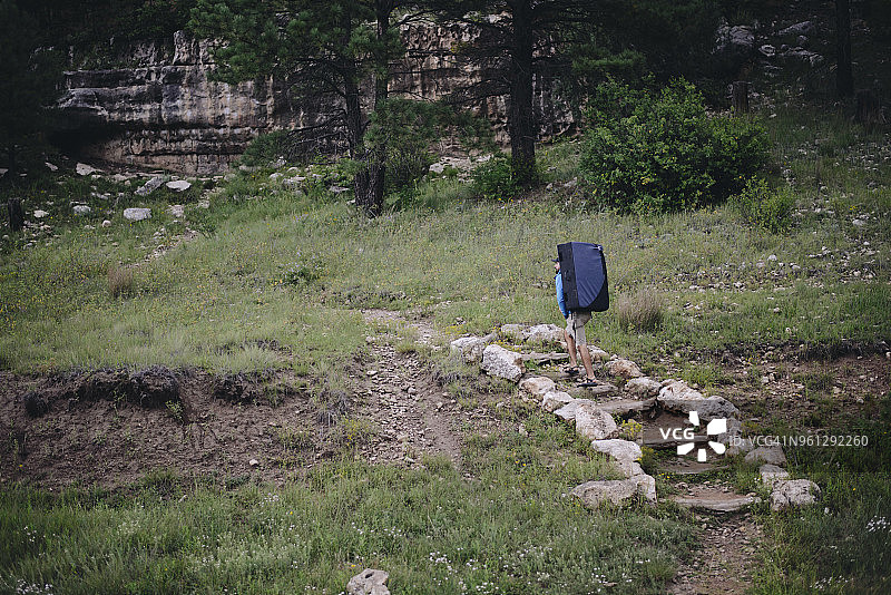徒步者携带抱石垫在森林草地上行走图片素材