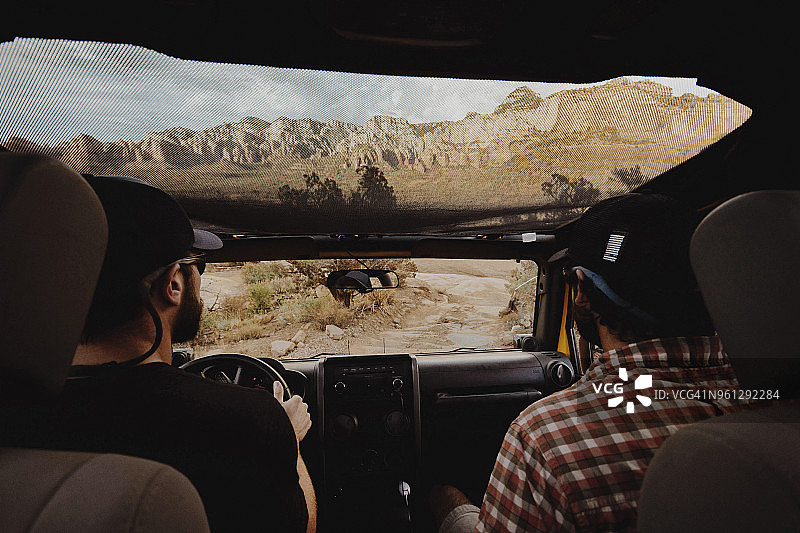 朋友们在土路上乘坐越野车的背影图片素材