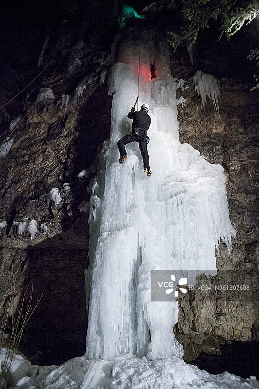 冰攀者攀登冰冻瀑布的低角度视图图片素材