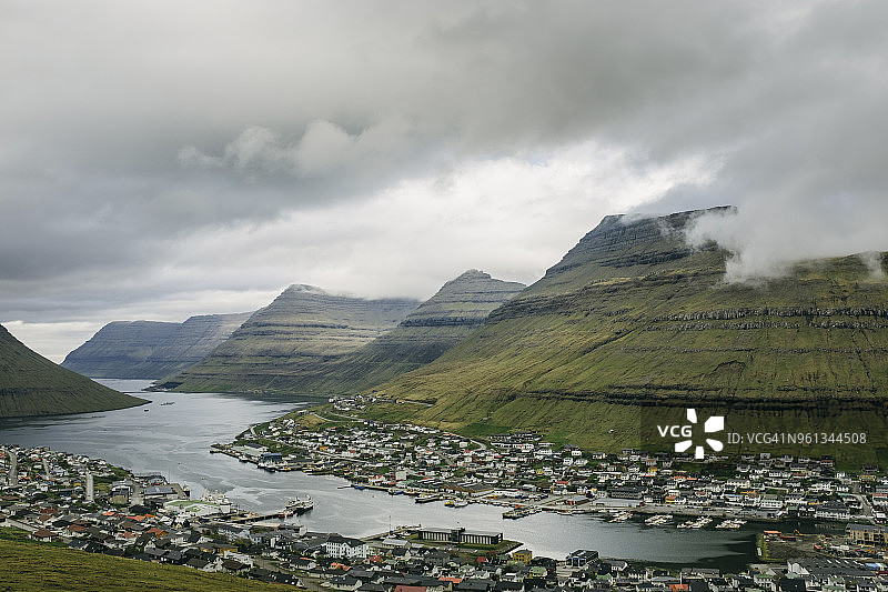河流旁的城镇，远山和多云天空的高角度视图图片素材