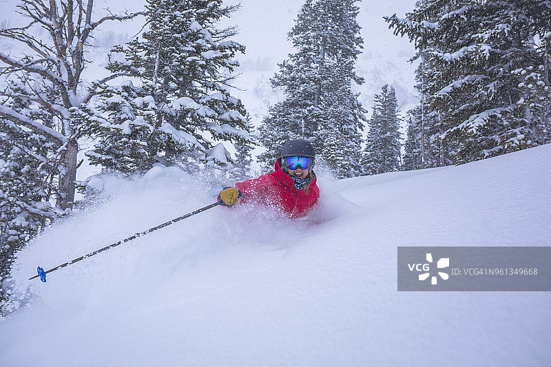 快乐的女人在白雪皑皑的风景上滑雪图片素材