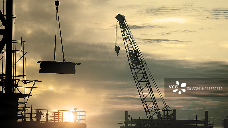 建筑工人和塔吊建造大型住宅楼剪影图片素材