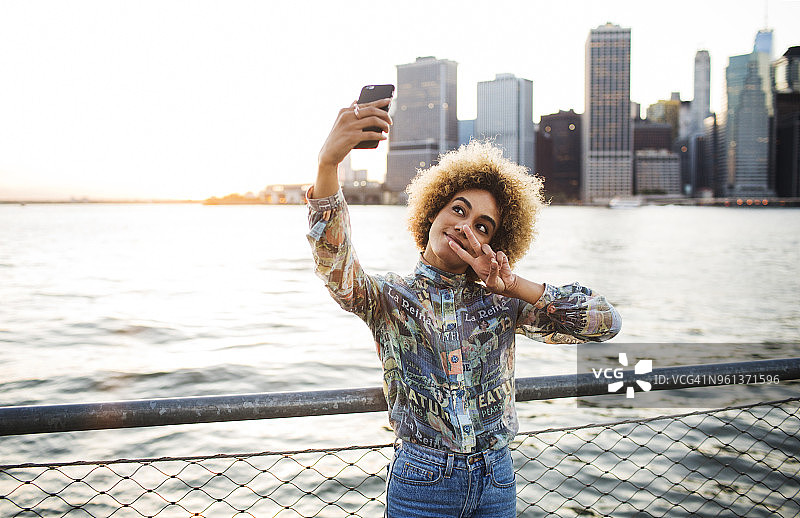 女人在河边用手机自拍图片素材