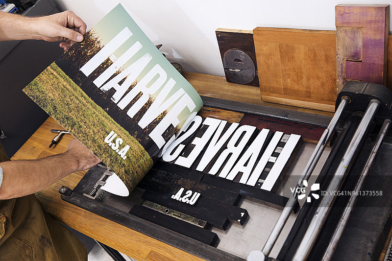 男子在海报上打印文字的局部照片图片素材