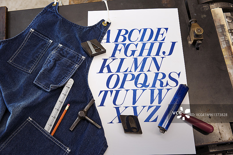 海报旁边的围裙和桌子上的工具的俯视图图片素材